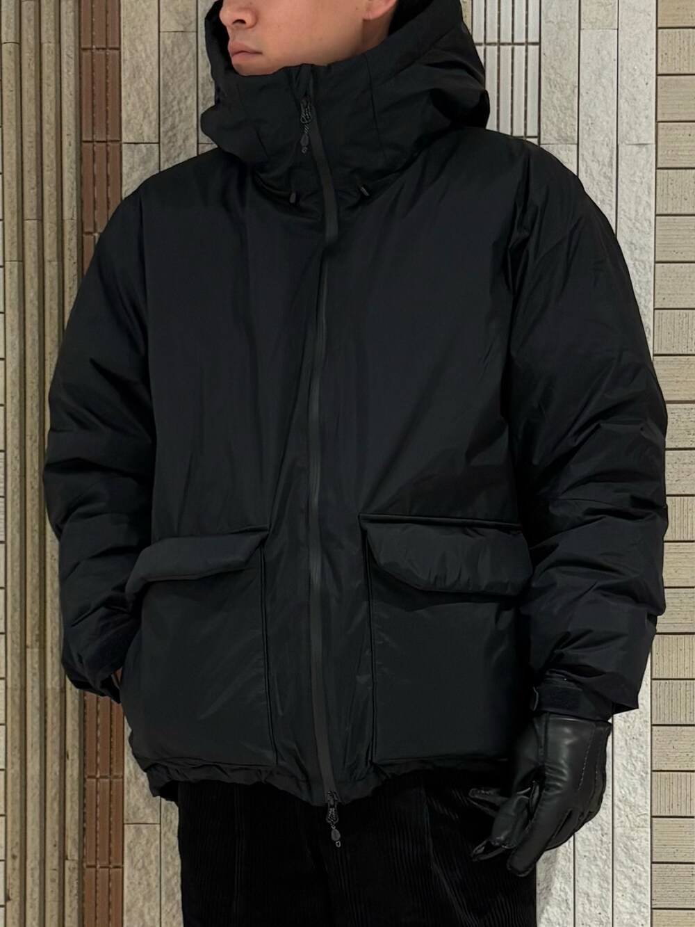 ブラック系のダウンジャケット/コート、グレー系のニット/セーター、ブラック系のその他パンツを着用したメンズの秋コーディネートの5枚目の写真