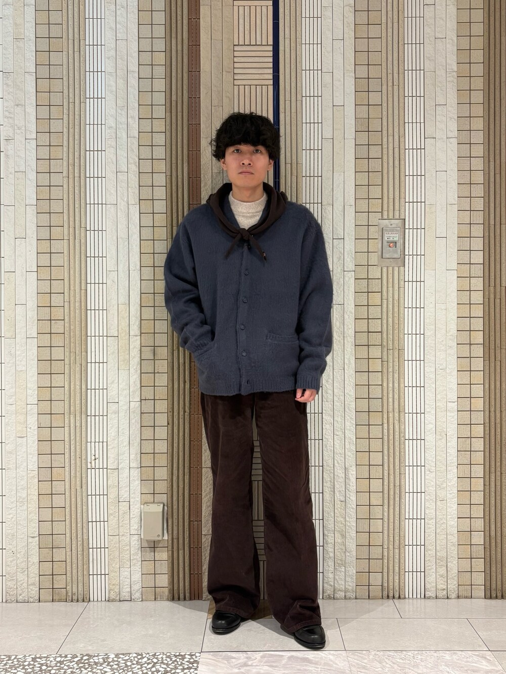 ブルー系のカーディガン/ボレロ、ベージュ系のニット/セーター、ブラウン系のバンダナ/スカーフを着用したメンズの冬コーディネートの2枚目の写真
