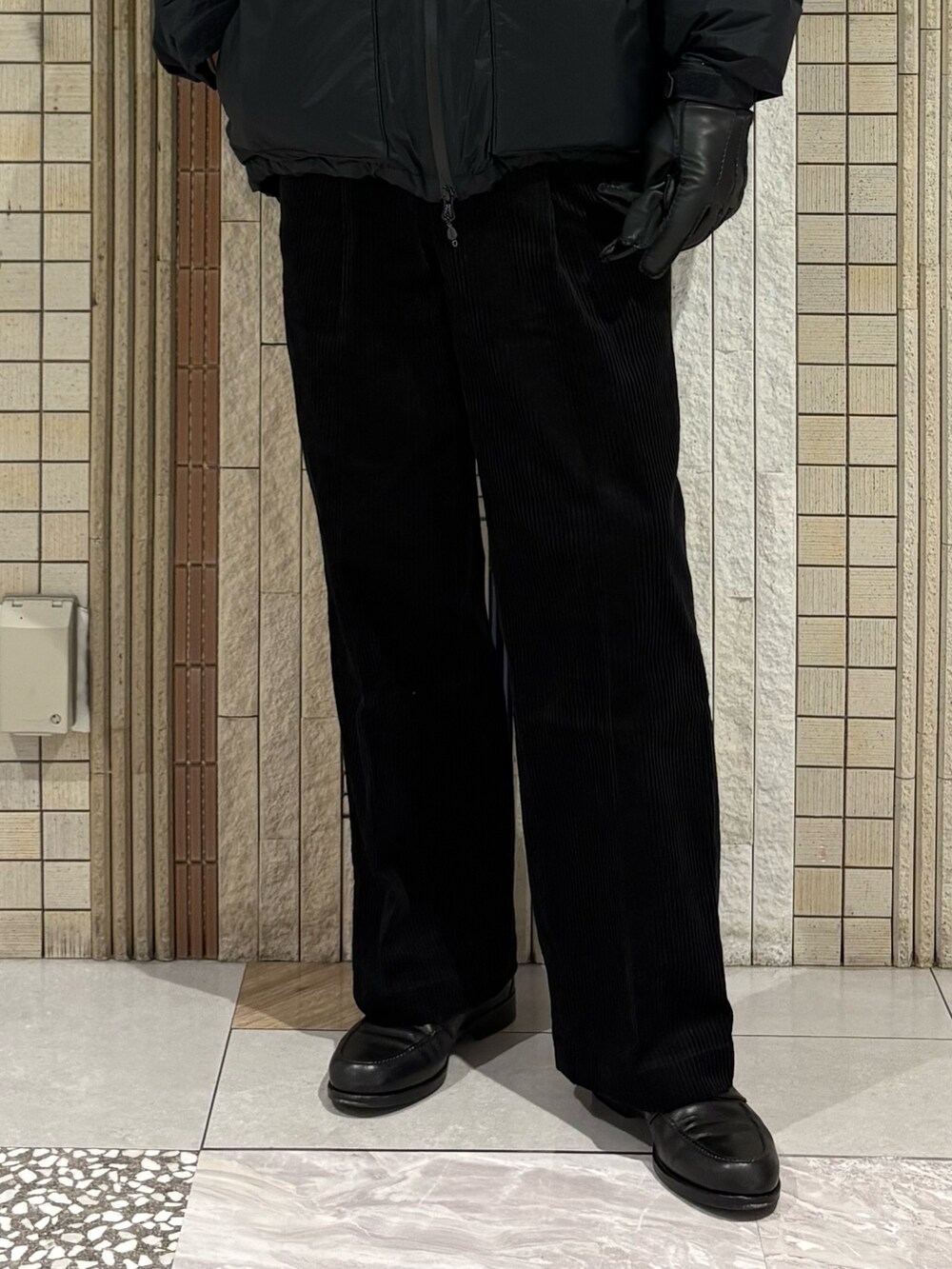 ブラック系のダウンジャケット/コート、グレー系のニット/セーター、ブラック系のその他パンツを着用したメンズの秋コーディネートの6枚目の写真