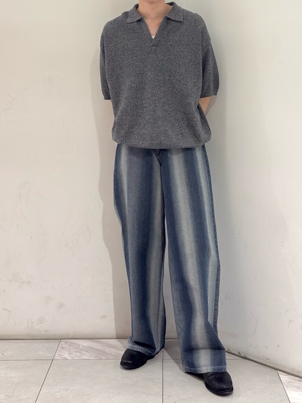 グレー系のニット/セーター、ブルー系のデニムパンツ、ブラック系のブーツを着用したメンズの春コーディネートの2枚目の写真