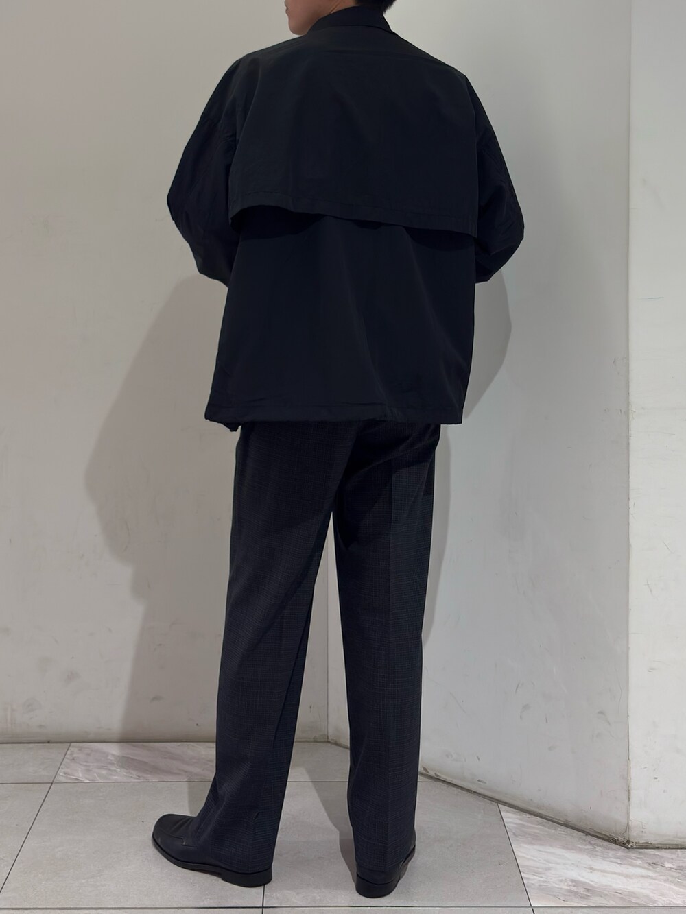 ブラック系のナイロンジャケット、グレー系のその他パンツを着用したメンズの春コーディネートの6枚目の写真