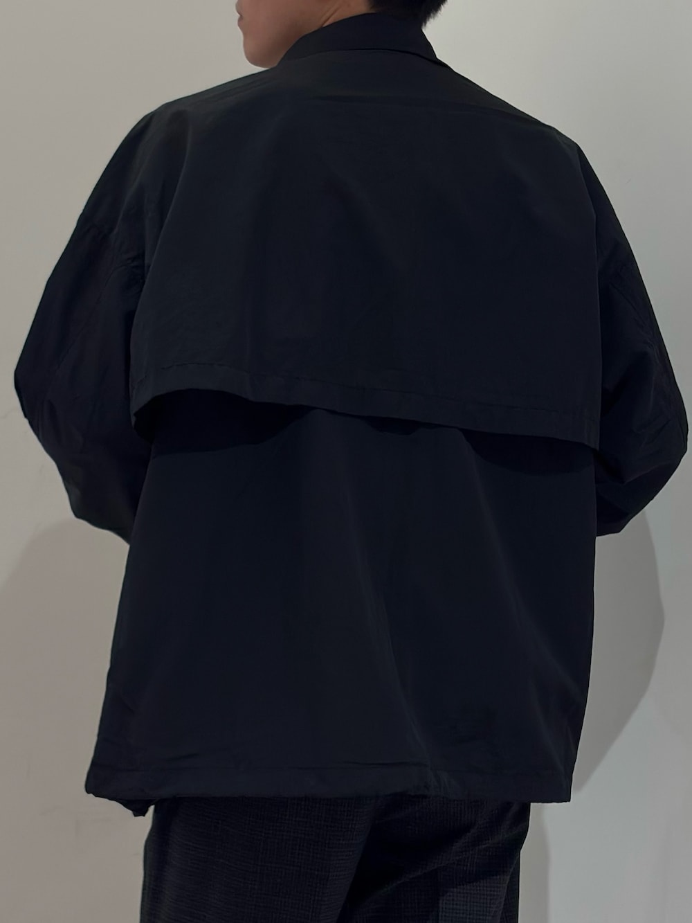 ブラック系のナイロンジャケット、グレー系のその他パンツを着用したメンズの春コーディネートの7枚目の写真