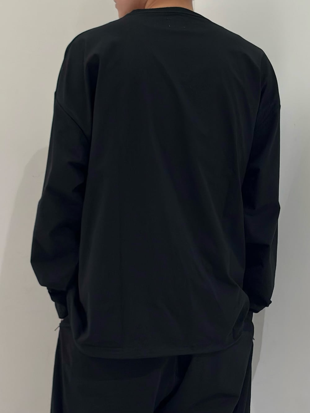 ブラック系のTシャツ/カットソー、ブラック系のその他パンツ、シルバー系のスニーカーを着用したメンズの春コーディネートの7枚目の写真