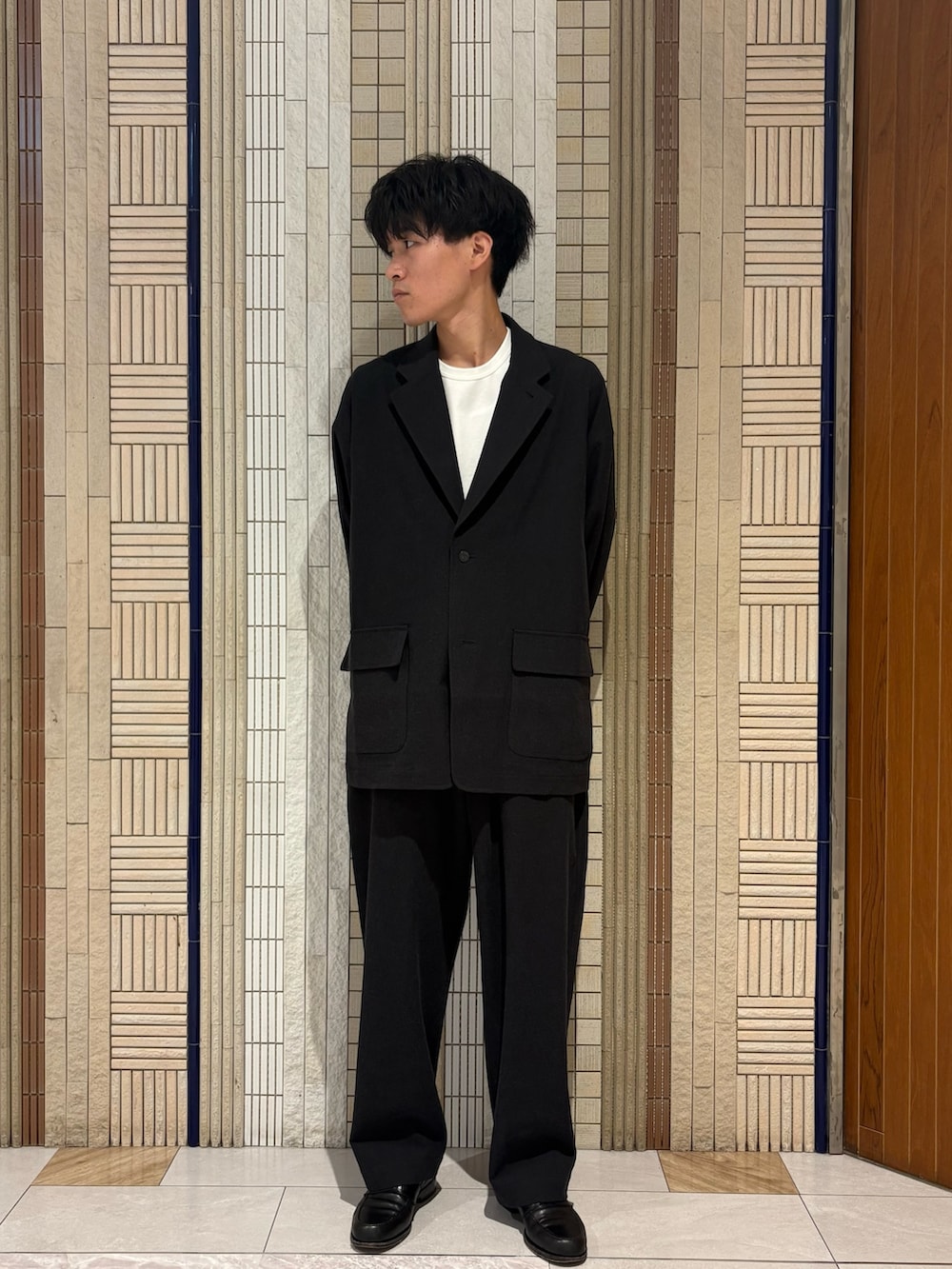 ブラック系のテーラードジャケット、ブラック系のその他パンツ、ホワイト系のTシャツ/カットソーを着用したメンズの夏コーディネートの2枚目の写真