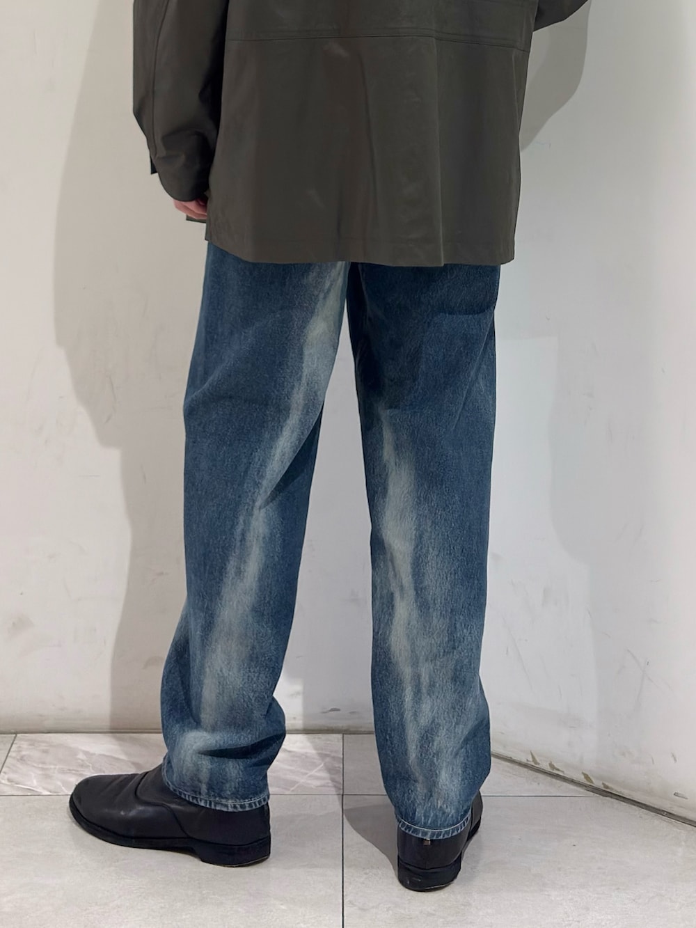 グリーン系のその他アウター、イエロー系のニット/セーター、ブルー系のデニムパンツを着用したメンズの春コーディネートの7枚目の写真