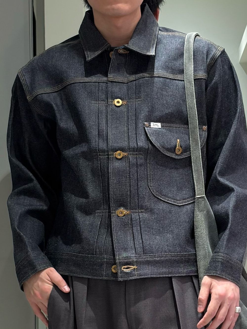グレー系のその他パンツ、ブラック系のドレスシューズ、ブルー系のデニムジャケットを着用したメンズの秋コーディネートの3枚目の写真
