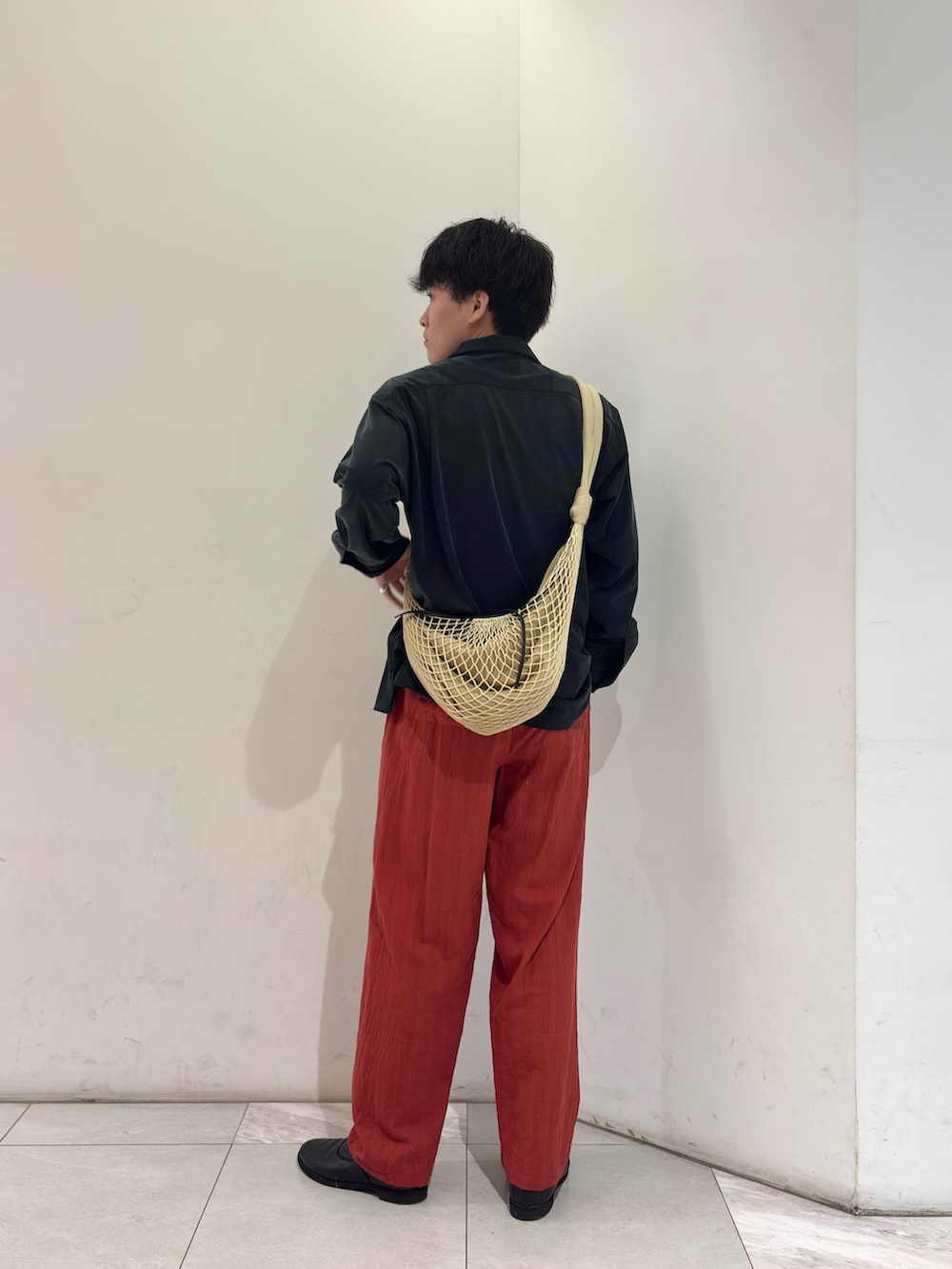 ブラック系のシャツ/ブラウス、ベージュ系のショルダーバッグ、ブラック系のブーツを着用したメンズの春コーディネートの5枚目の写真