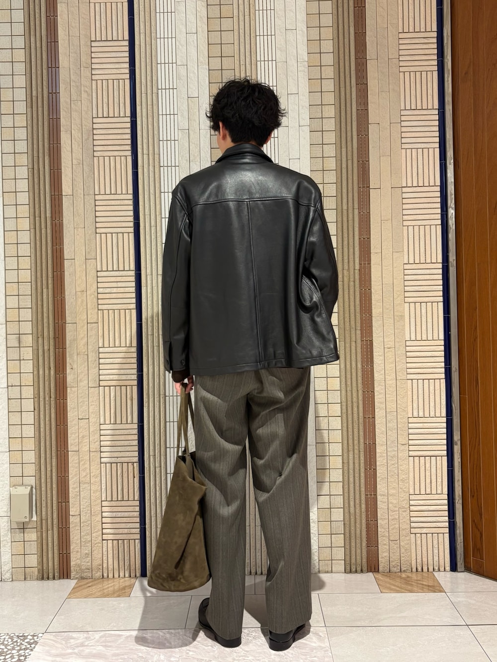 ブラウン系のニット/セーター、ブラック系のその他アウター、グレー系のその他パンツを着用したメンズの秋コーディネートの4枚目の写真