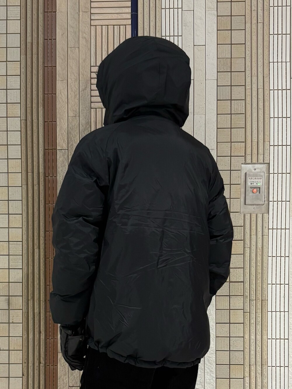 ブラック系のダウンジャケット/コート、グレー系のニット/セーター、ブラック系のその他パンツを着用したメンズの秋コーディネートの10枚目の写真