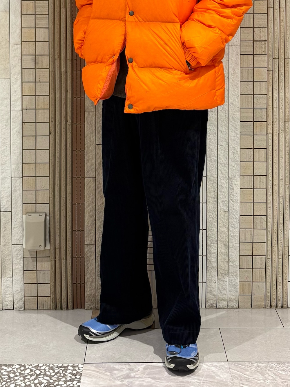 ブルー系のその他パンツ、ブルー系のスニーカー、オレンジ系のダウンジャケット/コートを着用したメンズの秋コーディネートの4枚目の写真