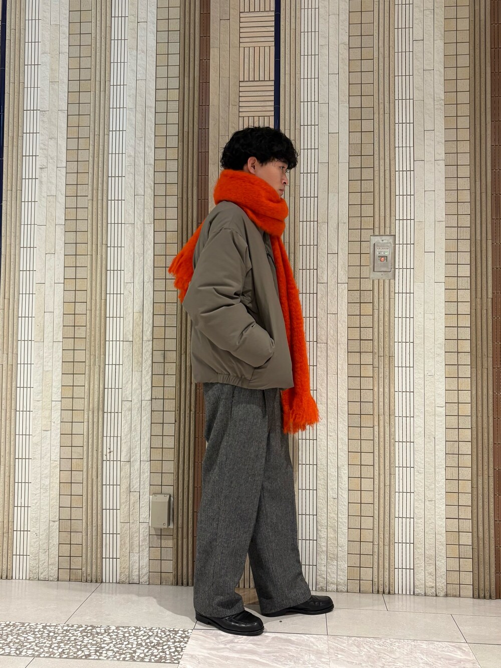 ベージュ系のダウンジャケット/コート、ブラウン系のニット/セーター、グレー系のその他パンツを着用したメンズの秋コーディネートの7枚目の写真