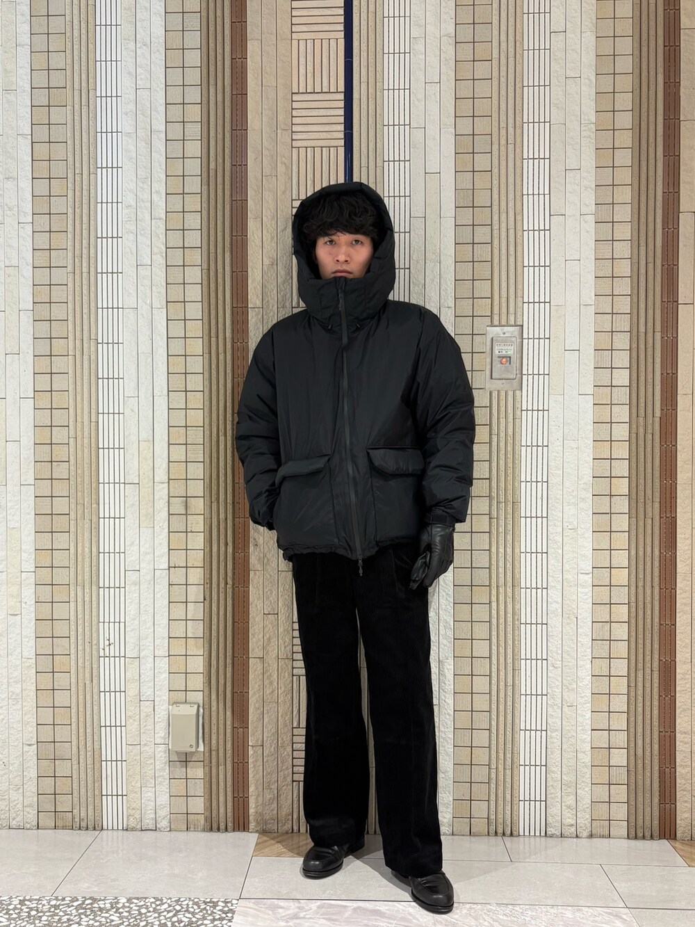 ブラック系のダウンジャケット/コート、グレー系のニット/セーター、ブラック系のその他パンツを着用したメンズの秋コーディネートの3枚目の写真