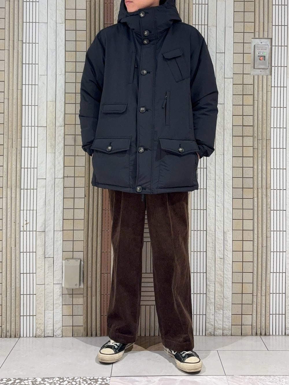 ブラック系のダウンジャケット/コート、ブラック系のニット/セーター、ブラウン系のその他パンツを着用したメンズの冬コーディネートの3枚目の写真