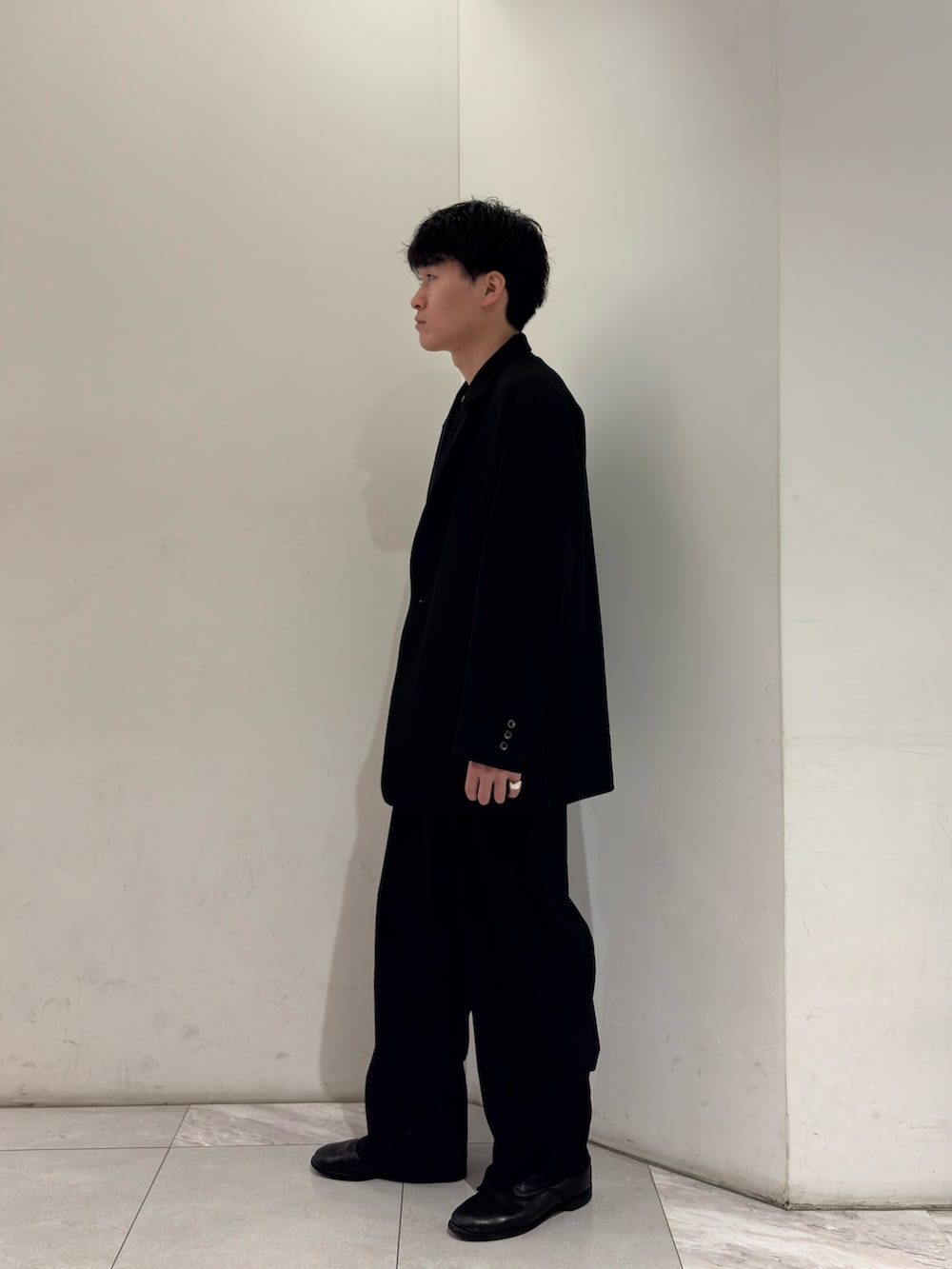 ブラック系のその他アウター、イエロー系のニット/セーター、ブラック系のその他パンツを着用したメンズの春コーディネートの4枚目の写真