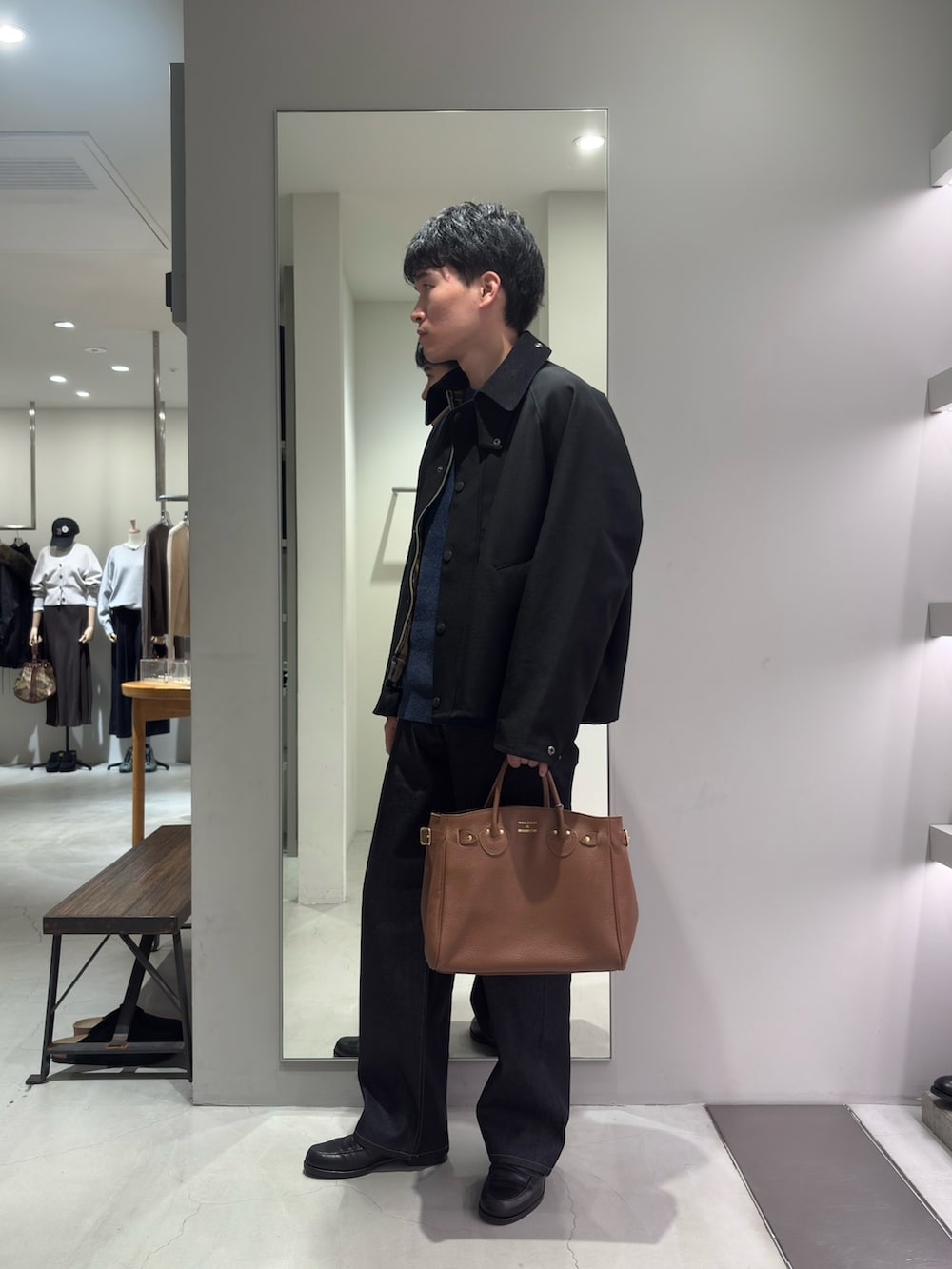 ブラック系のその他アウター、ブルー系のニット/セーター、ブルー系のデニムパンツを着用したメンズの秋コーディネートの4枚目の写真