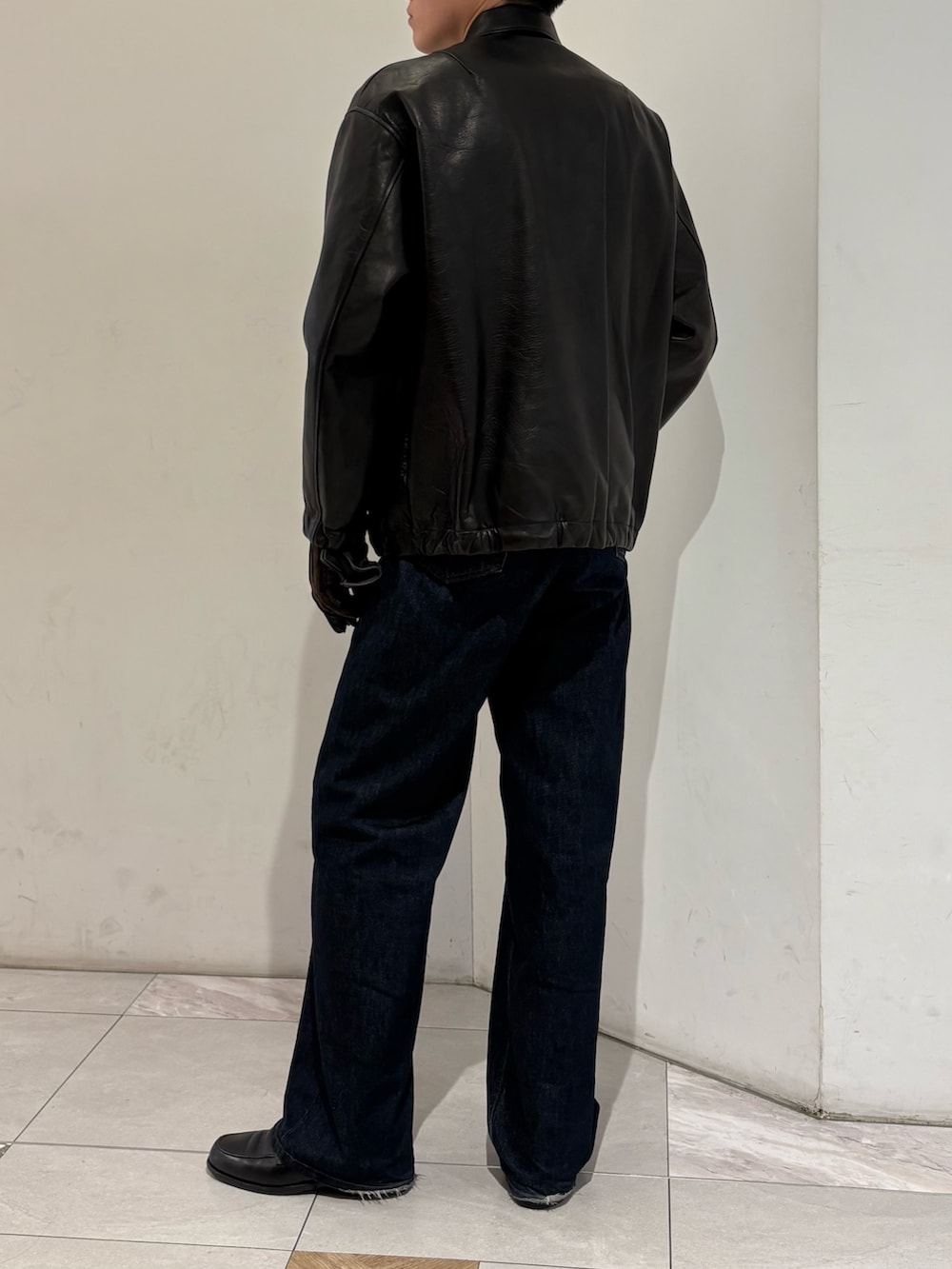 ブラック系のテーラードジャケット、ブラウン系の手袋を着用したメンズの冬コーディネートの7枚目の写真