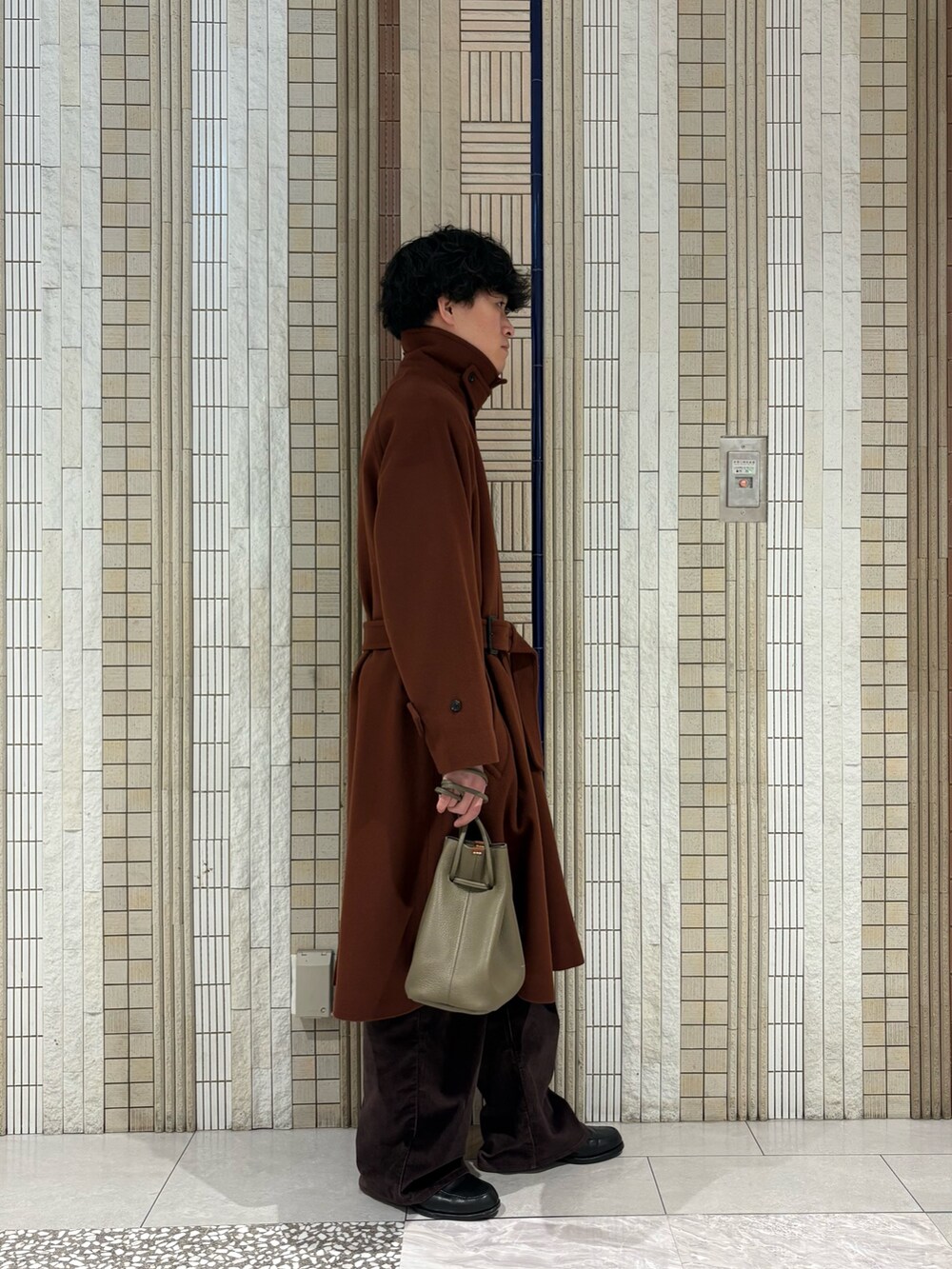 ブラウン系のステンカラーコート、ホワイト系のニット/セーター、ベージュ系のその他雑貨を着用したメンズの冬コーディネートの7枚目の写真