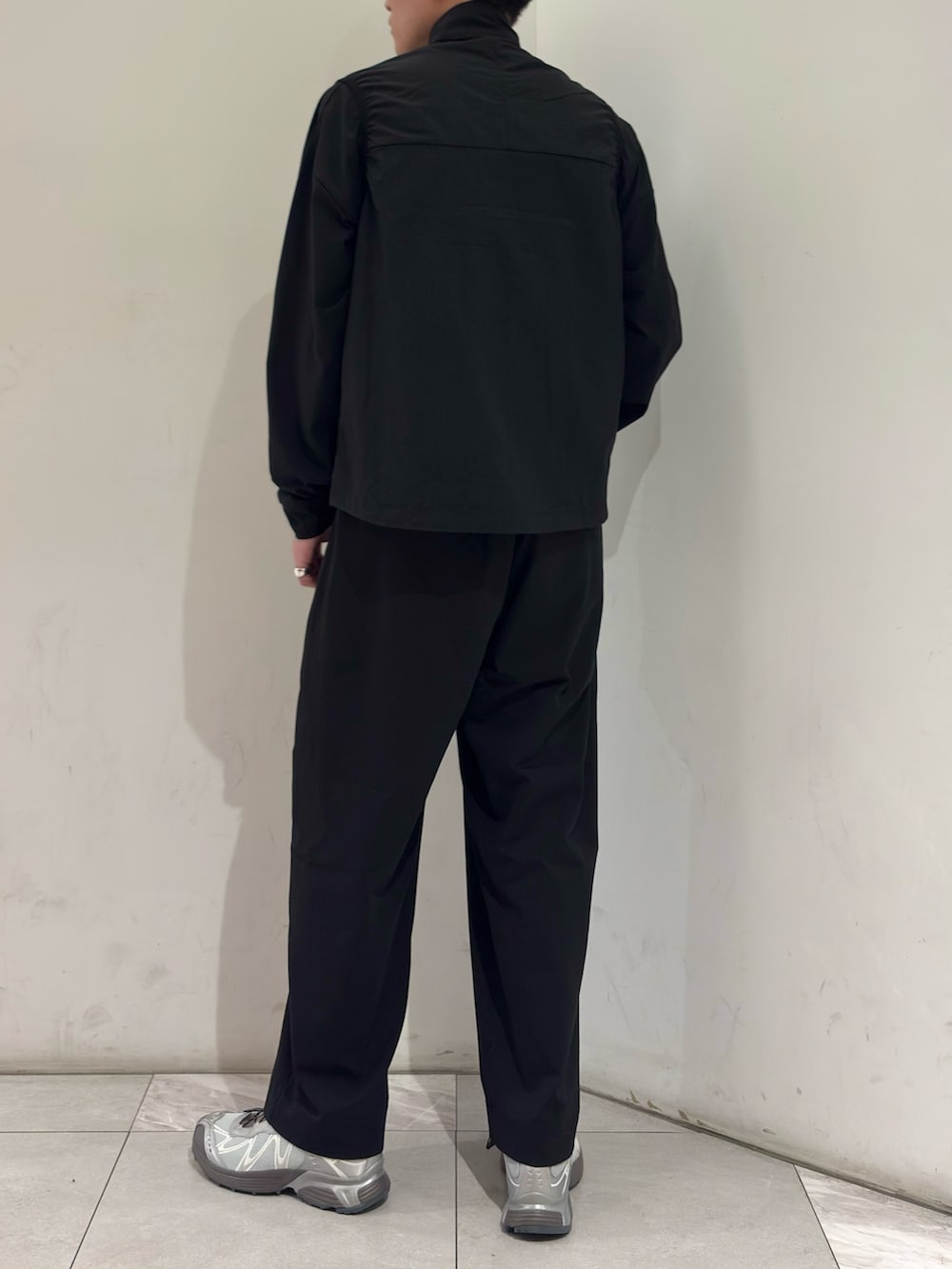 ブラック系のTシャツ/カットソー、ブラック系のその他パンツ、シルバー系のスニーカーを着用したメンズの春コーディネートの6枚目の写真