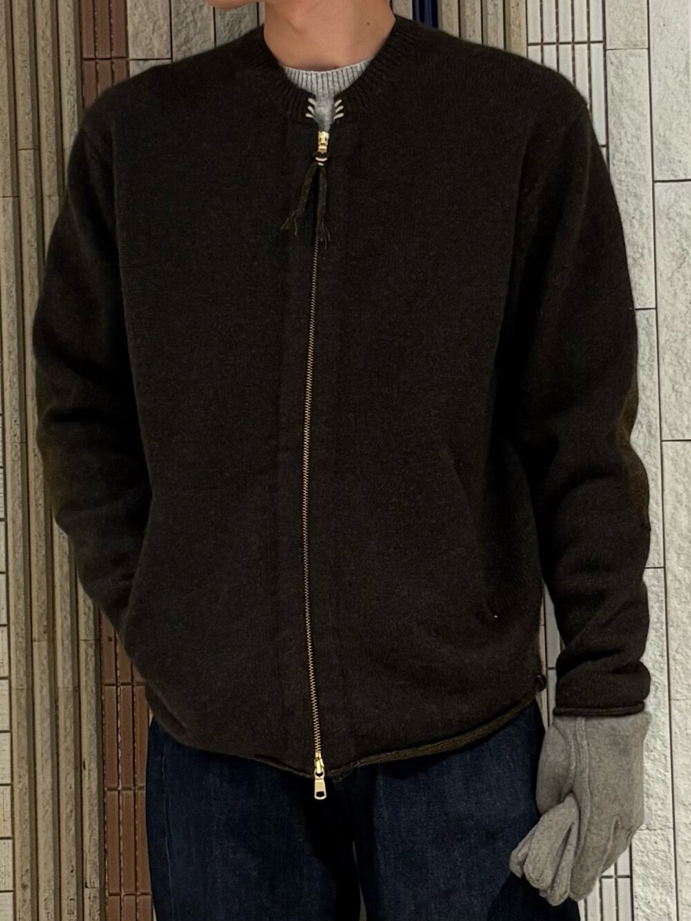 グレー系のニット/セーター、グレー系の手袋を着用したメンズの秋コーディネートの6枚目の写真