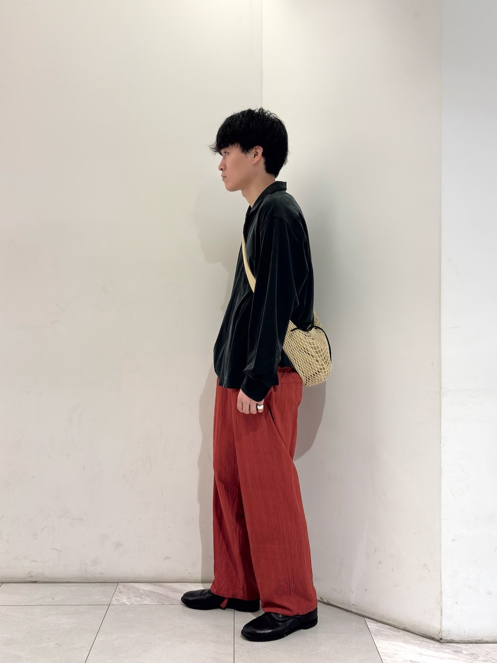 ブラック系のシャツ/ブラウス、ベージュ系のショルダーバッグ、ブラック系のブーツを着用したメンズの春コーディネートの4枚目の写真