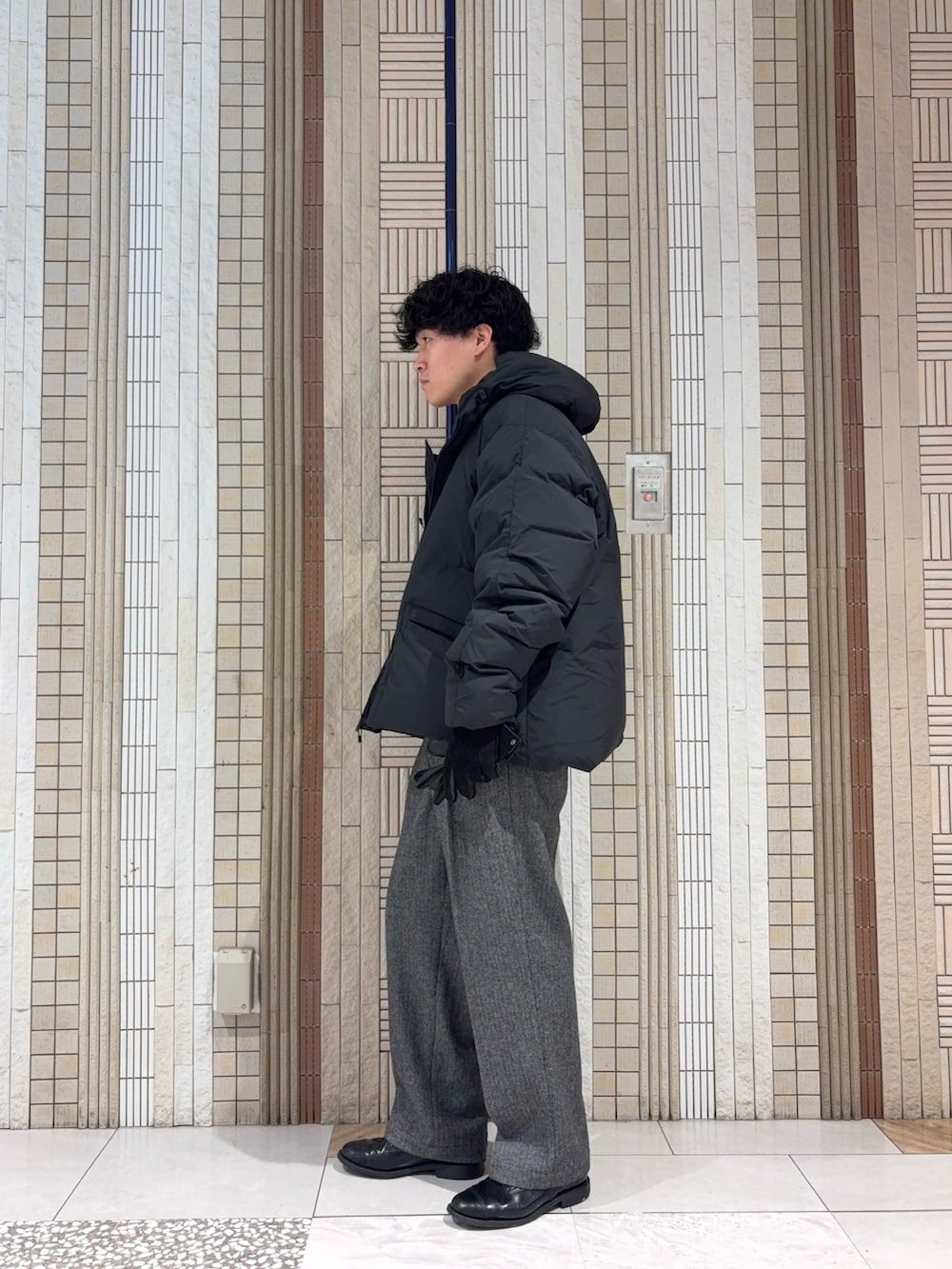 ブラック系のダッフルコート、グレー系のニット/セーター、グレー系のその他パンツを着用したメンズの冬コーディネートの6枚目の写真