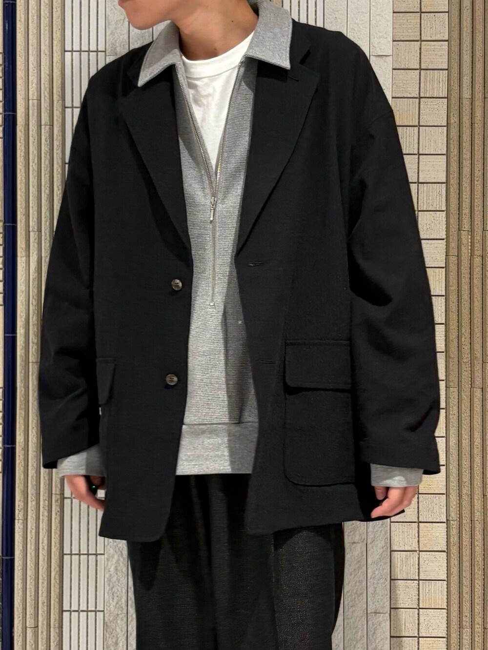 グレー系のTシャツ/カットソー、ブラック系のテーラードジャケットを着用したメンズの秋コーディネートの6枚目の写真