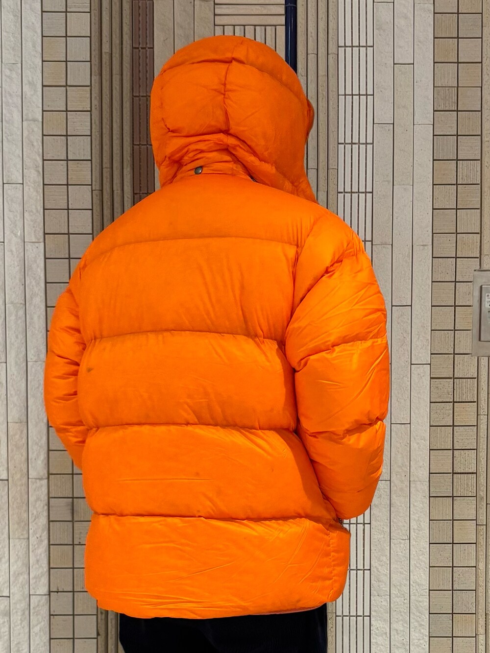 ブルー系のその他パンツ、ブルー系のスニーカー、オレンジ系のダウンジャケット/コートを着用したメンズの秋コーディネートの9枚目の写真