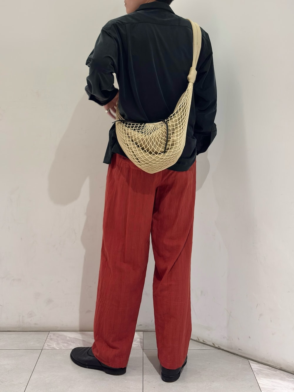 ブラック系のシャツ/ブラウス、ベージュ系のショルダーバッグ、ブラック系のブーツを着用したメンズの春コーディネートの6枚目の写真