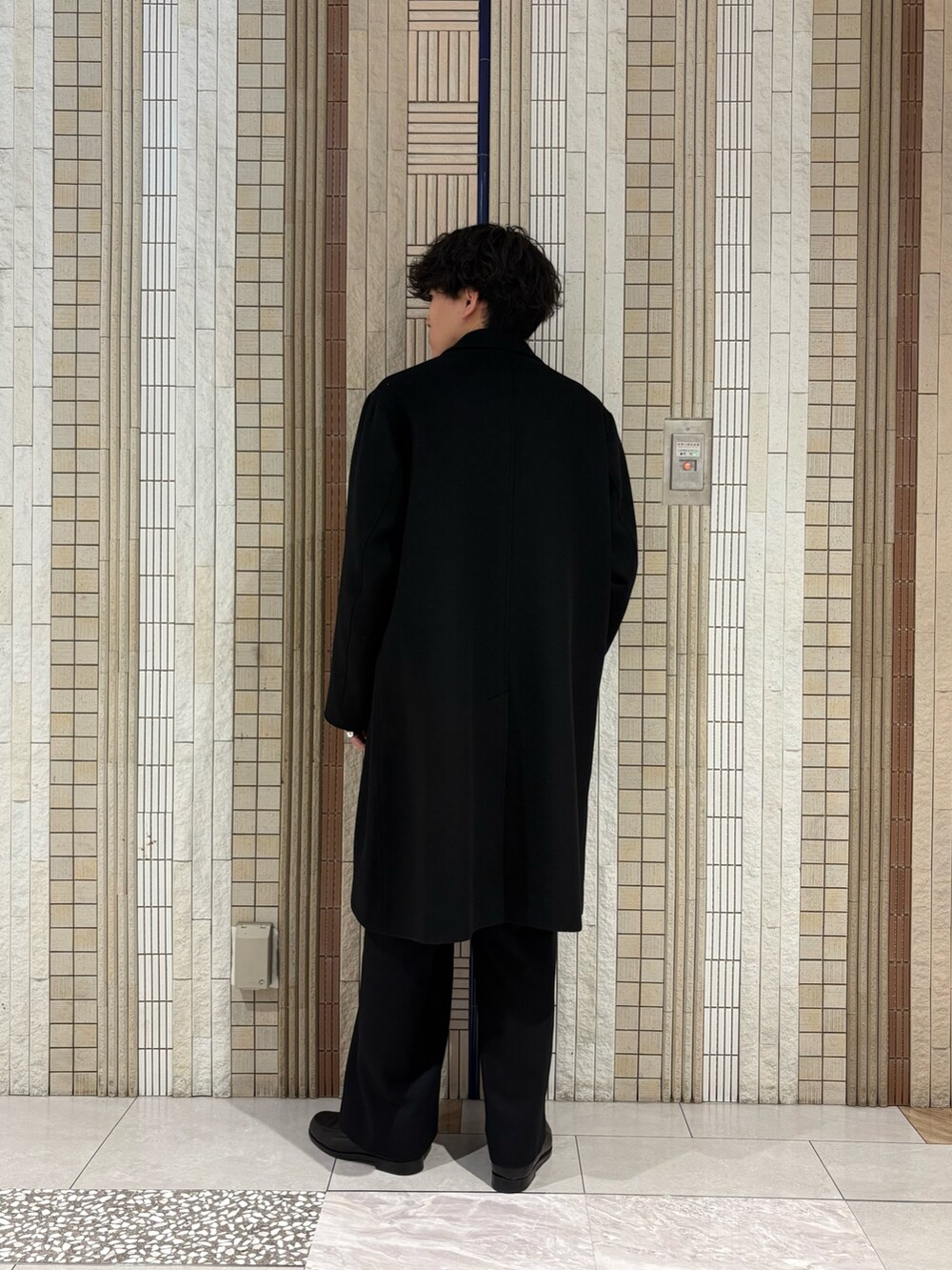 ブラック系のチェスターコート、グレー系のカーディガン/ボレロを着用したメンズの冬コーディネートの7枚目の写真