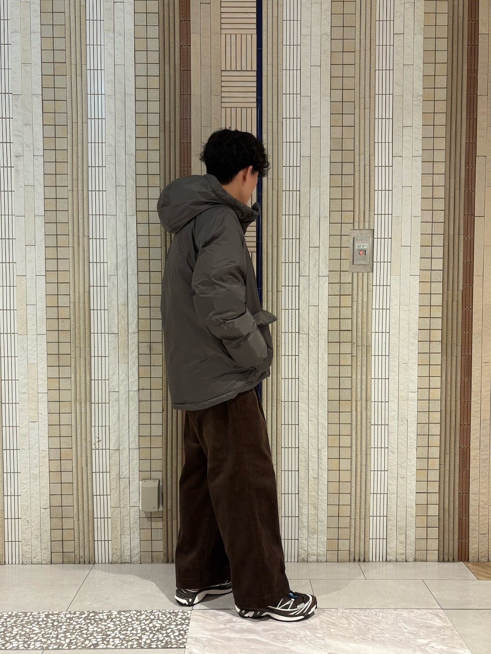 グレー系のダウンジャケット/コート、レッド系のニット/セーター、ブラウン系のその他パンツを着用したメンズの秋コーディネートの6枚目の写真