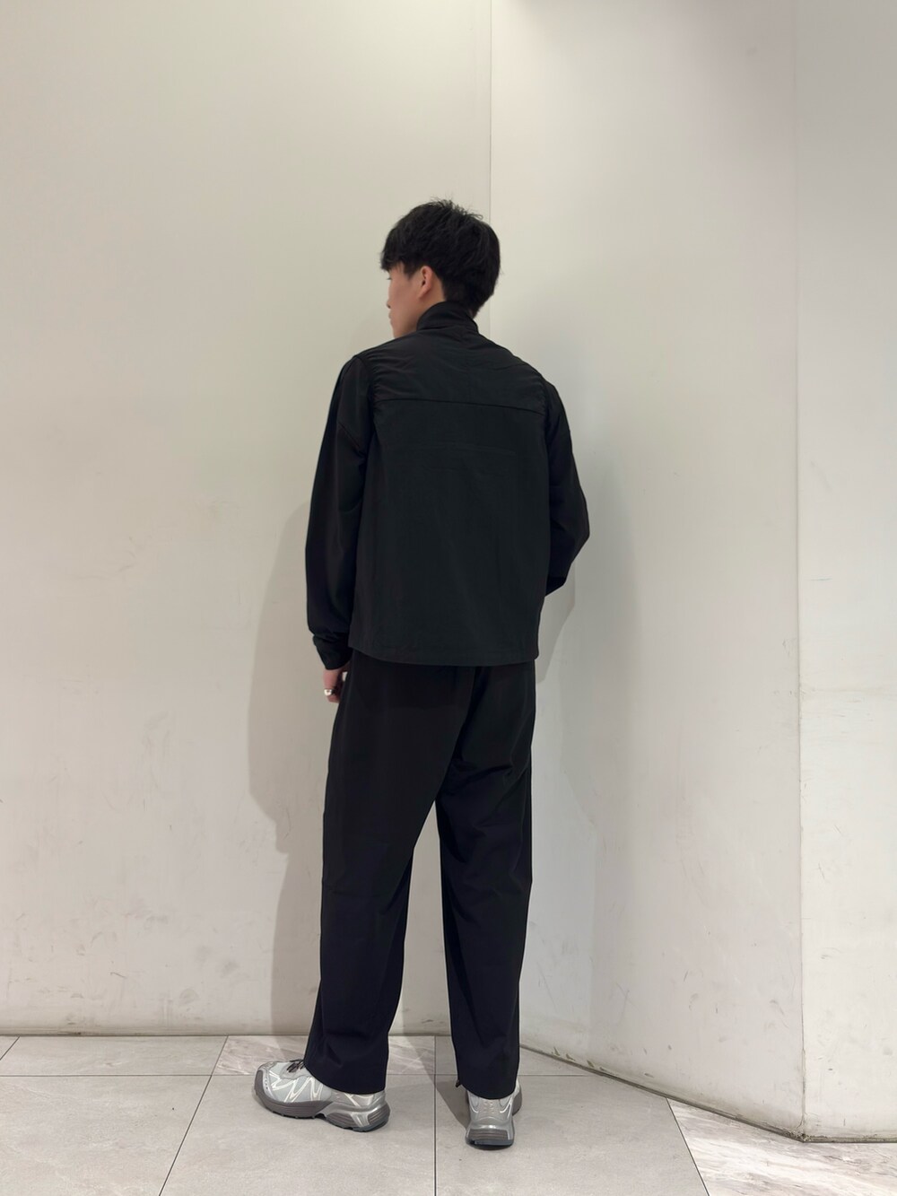 ブラック系のTシャツ/カットソー、ブラック系のその他パンツ、シルバー系のスニーカーを着用したメンズの春コーディネートの5枚目の写真