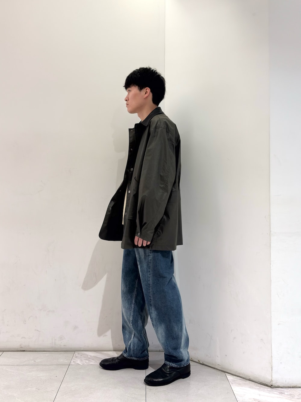 グリーン系のその他アウター、イエロー系のニット/セーター、ブルー系のデニムパンツを着用したメンズの春コーディネートの4枚目の写真