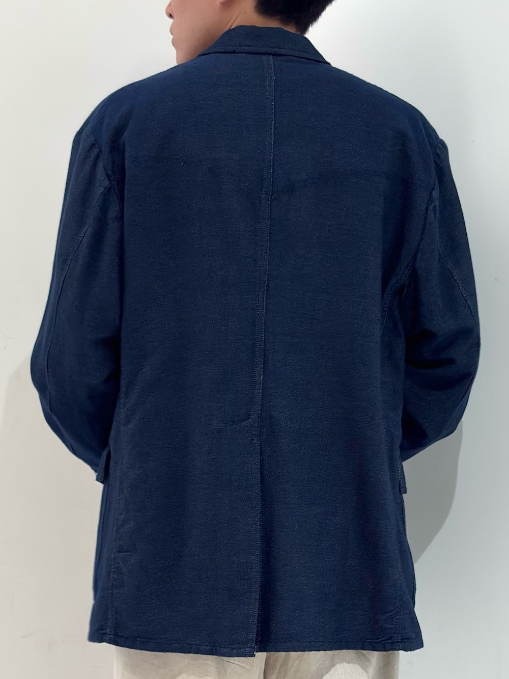 ブルー系のテーラードジャケット、オレンジ系のニット/セーター、ベージュ系のその他パンツを着用したメンズの春コーディネートの5枚目の写真