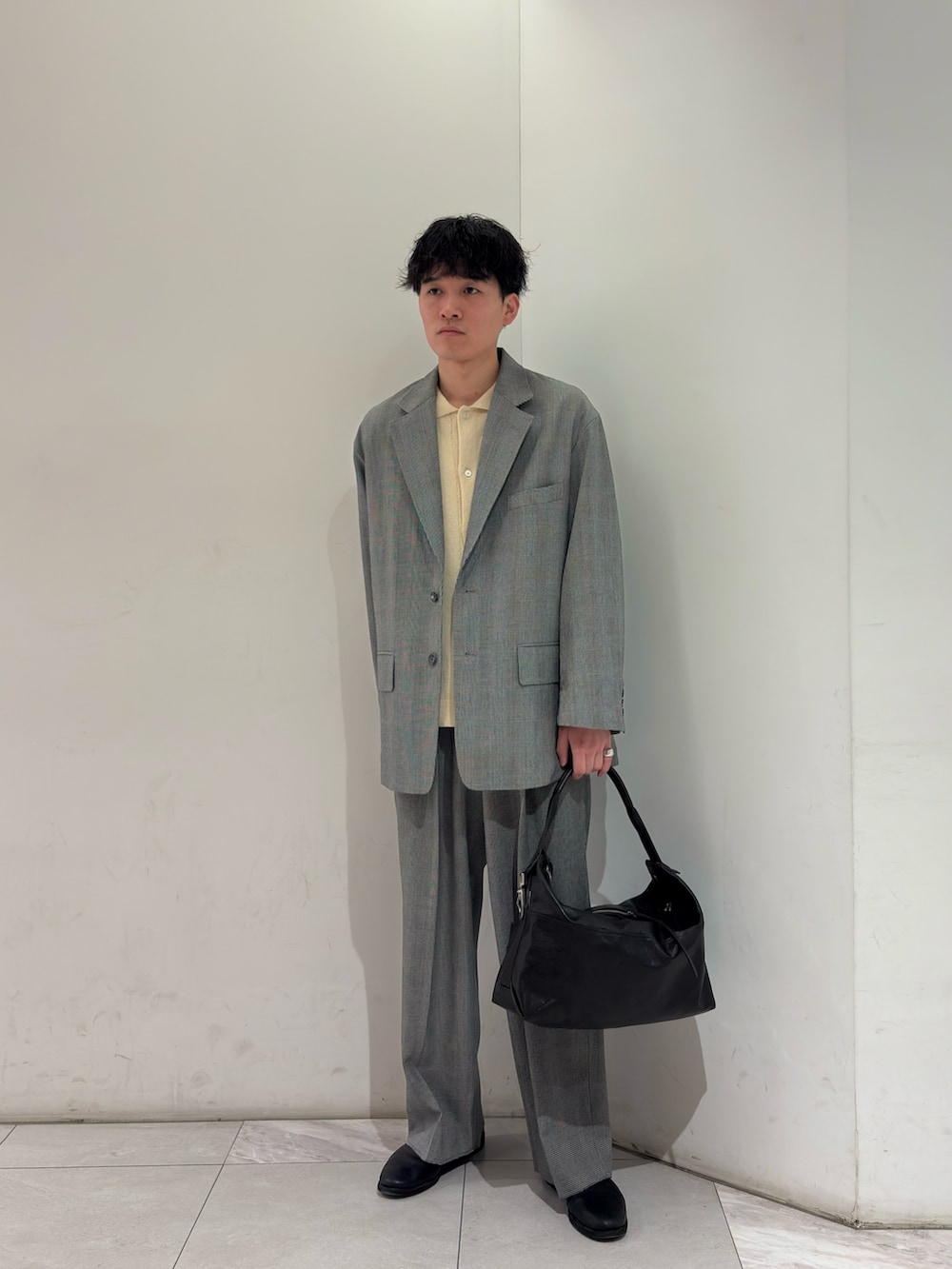 イエロー系のニット/セーター、ブラック系のブーツを着用したメンズの春コーディネートの2枚目の写真