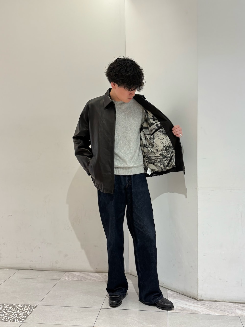 ブラック系のテーラードジャケット、ブラウン系の手袋を着用したメンズの冬コーディネートの4枚目の写真