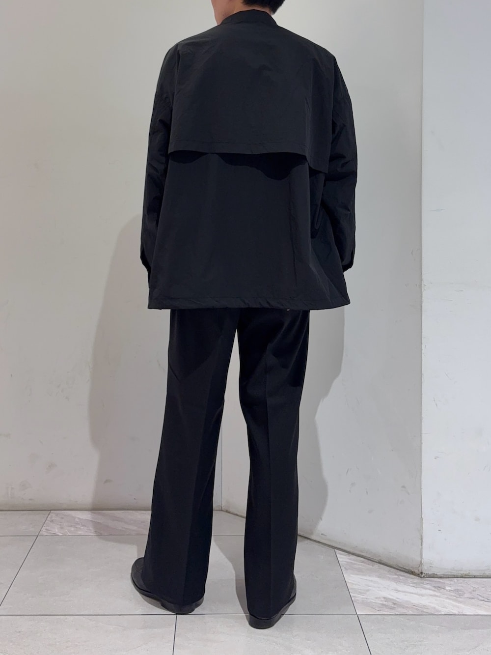 ブラック系のその他アウター、グレー系のニット/セーター、ブラック系のその他パンツを着用したメンズの冬コーディネートの6枚目の写真