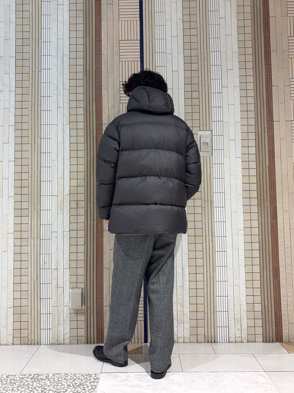 グリーン系のダウンジャケット/コート、ブラック系のニット/セーター、グレー系のその他パンツを着用したメンズの冬コーディネートの7枚目の写真