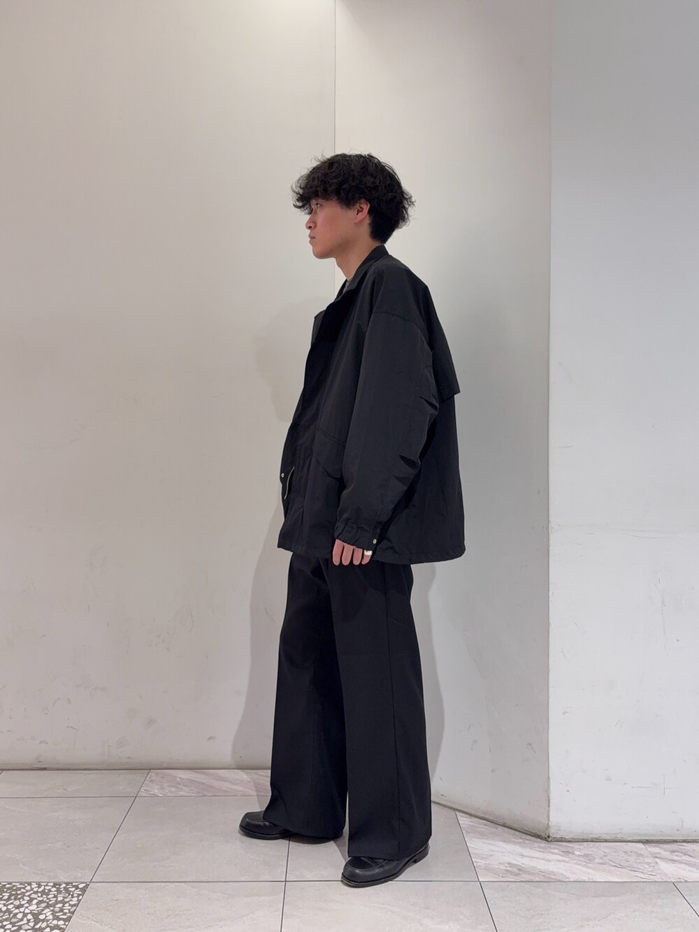 ブラック系のその他アウター、グレー系のニット/セーター、ブラック系のその他パンツを着用したメンズの冬コーディネートの4枚目の写真