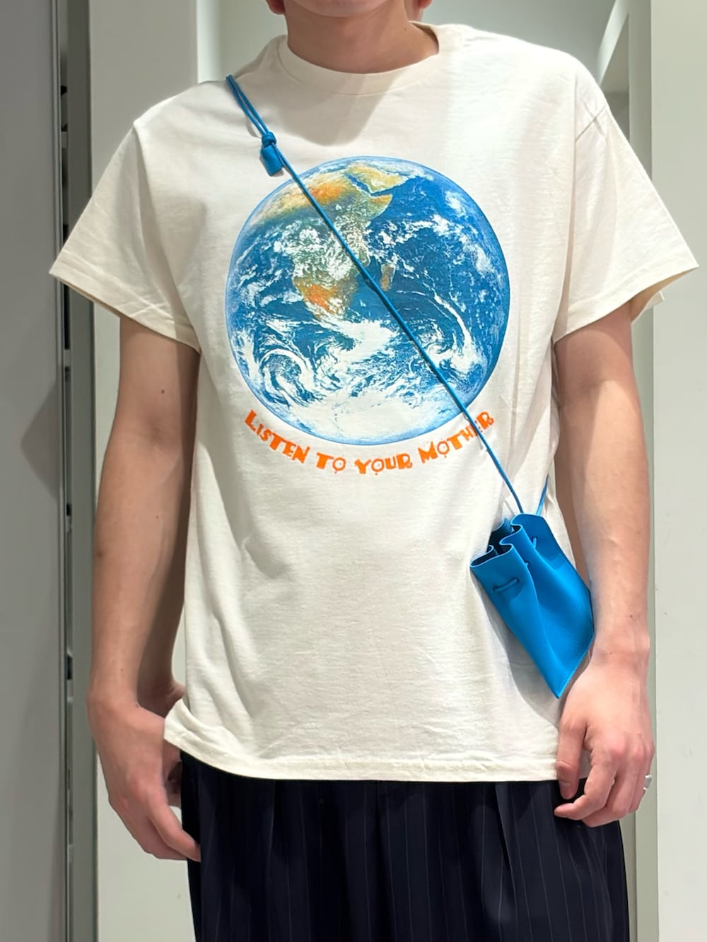 ホワイト系のTシャツ/カットソー、ブルー系のその他パンツ、オレンジ系のスニーカーを着用したメンズの夏コーディネートの3枚目の写真