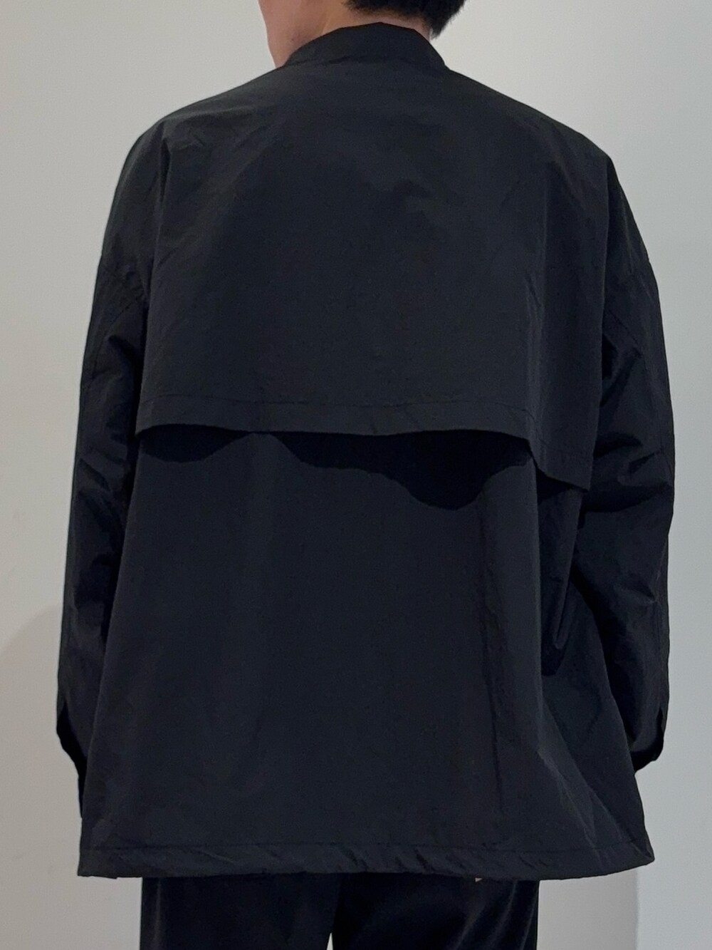 ブラック系のその他アウター、グレー系のニット/セーター、ブラック系のその他パンツを着用したメンズの冬コーディネートの7枚目の写真