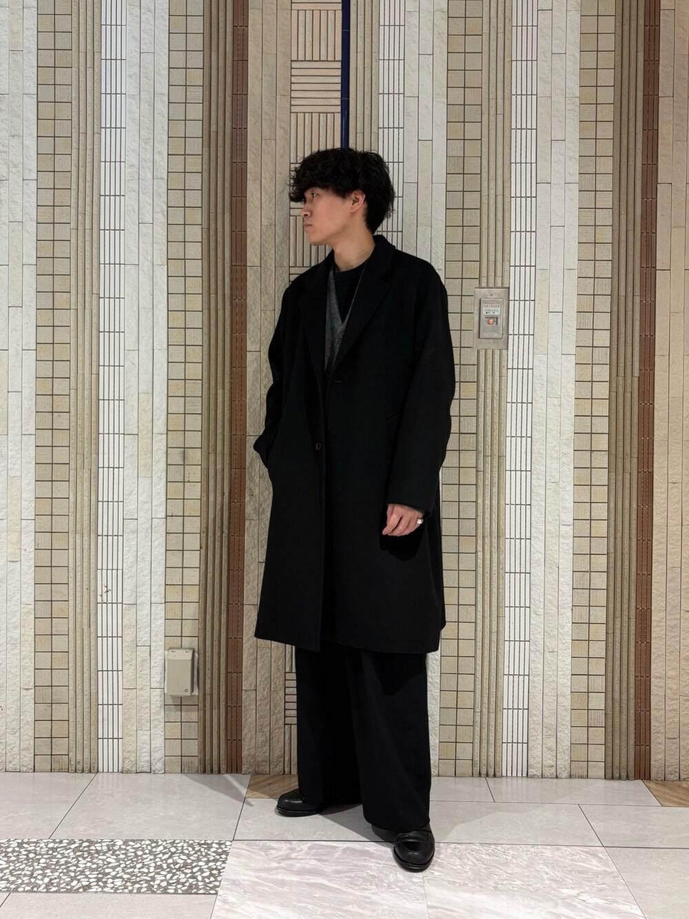 ブラック系のチェスターコート、グレー系のカーディガン/ボレロを着用したメンズの冬コーディネートの3枚目の写真