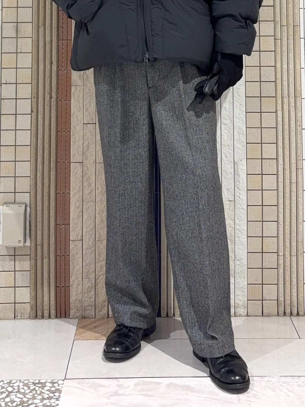 ブラック系のダッフルコート、グレー系のニット/セーター、グレー系のその他パンツを着用したメンズの冬コーディネートの5枚目の写真