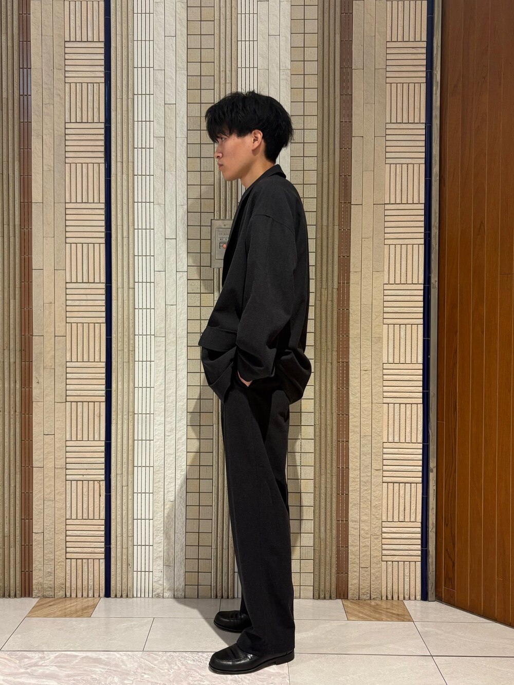 ブラック系のテーラードジャケット、ブラック系のその他パンツ、ホワイト系のTシャツ/カットソーを着用したメンズの夏コーディネートの3枚目の写真