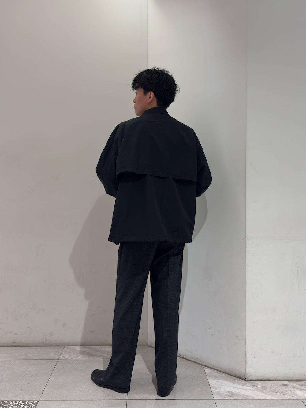 ブラック系のナイロンジャケット、グレー系のその他パンツを着用したメンズの春コーディネートの5枚目の写真