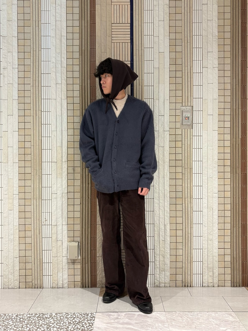 ブルー系のカーディガン/ボレロ、ベージュ系のニット/セーター、ブラウン系のバンダナ/スカーフを着用したメンズの冬コーディネートの3枚目の写真