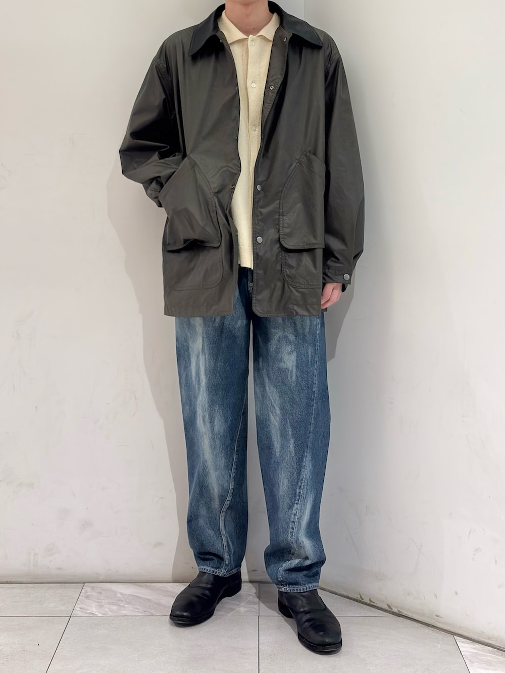 グリーン系のその他アウター、イエロー系のニット/セーター、ブルー系のデニムパンツを着用したメンズの春コーディネートの2枚目の写真