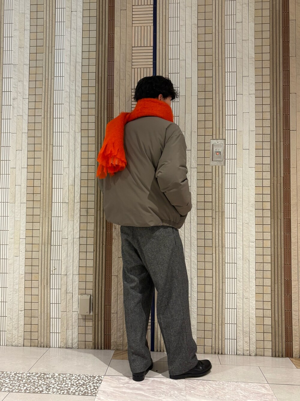 ベージュ系のダウンジャケット/コート、ブラウン系のニット/セーター、グレー系のその他パンツを着用したメンズの秋コーディネートの8枚目の写真