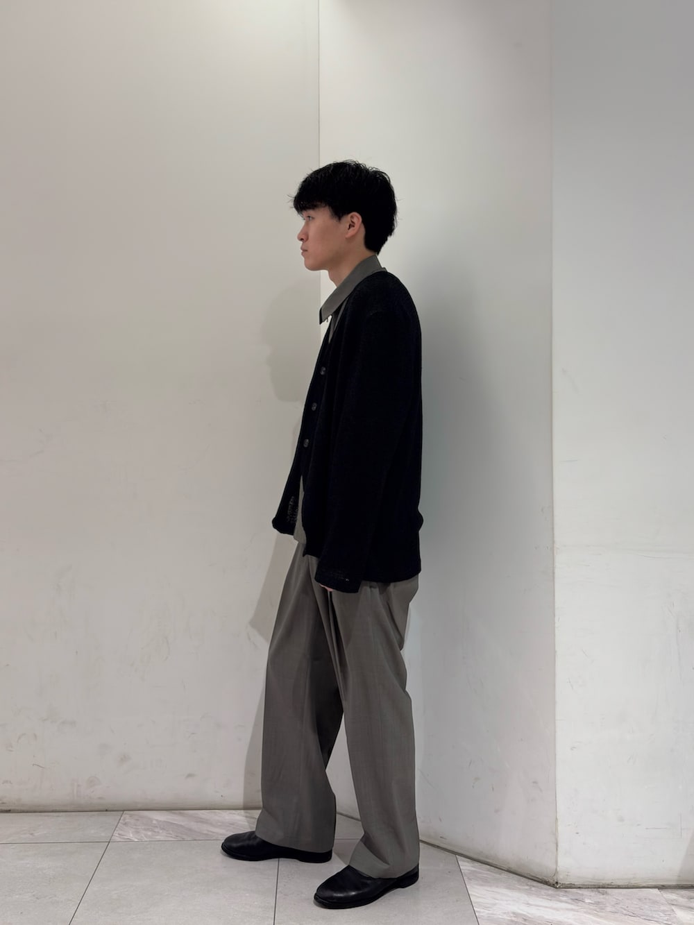 ブラック系のニット/セーター、ブラック系のベスト、グレー系のブルゾンを着用したメンズの春コーディネートの4枚目の写真