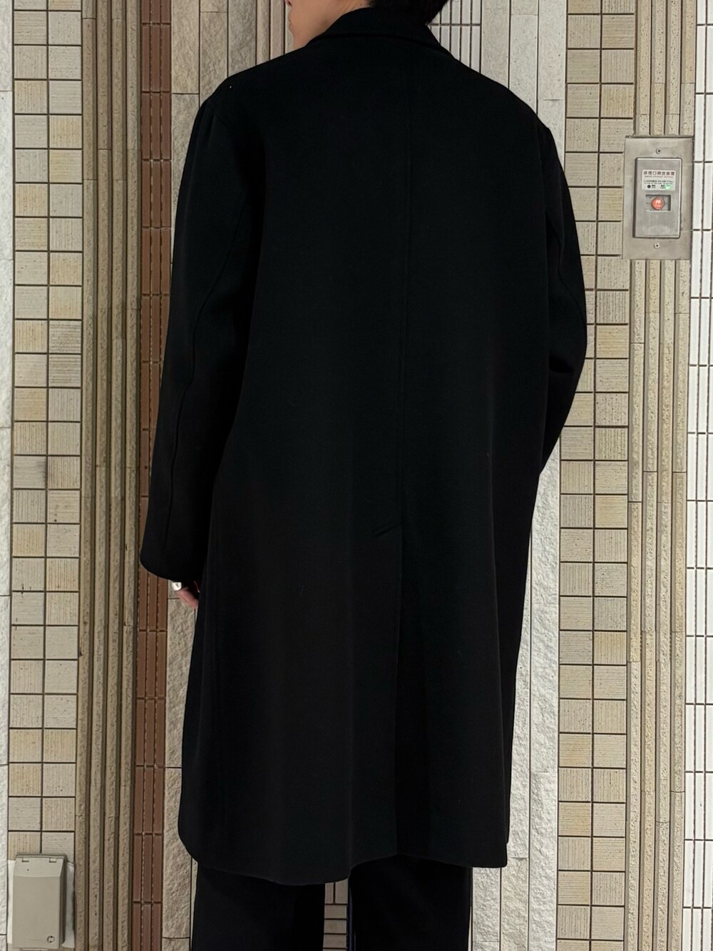 ブラック系のチェスターコート、グレー系のカーディガン/ボレロを着用したメンズの冬コーディネートの8枚目の写真