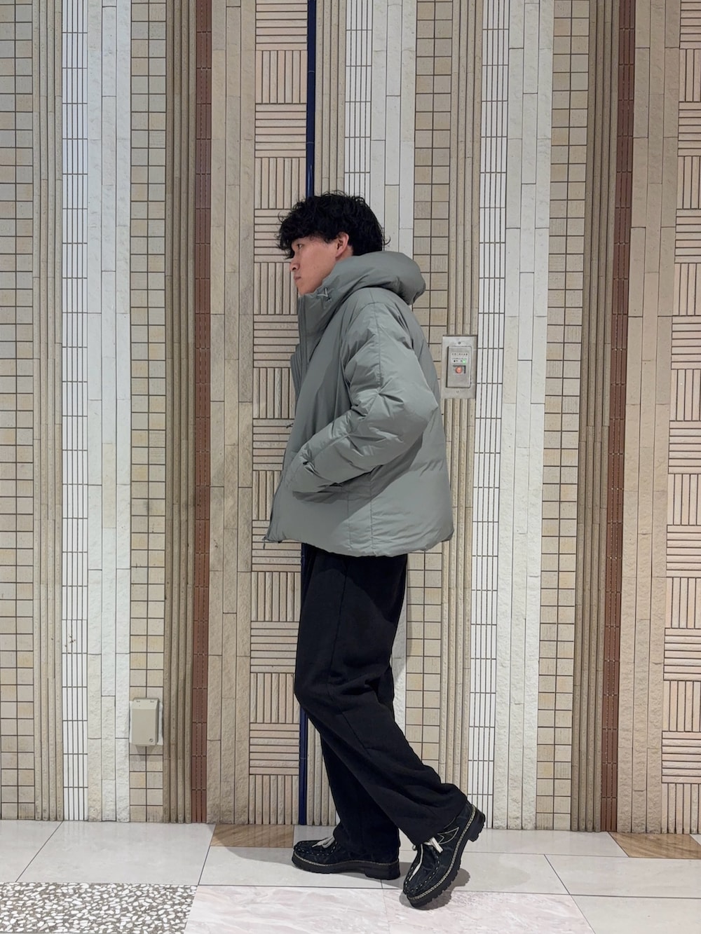 グレー系のダッフルコート、ブラック系のニット/セーター、ブラック系のその他パンツを着用したメンズの秋コーディネートの6枚目の写真